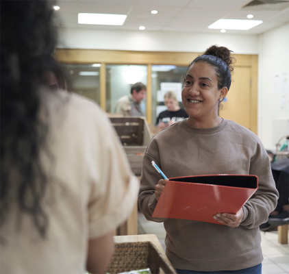 Woman holding a folder getting information from another woman